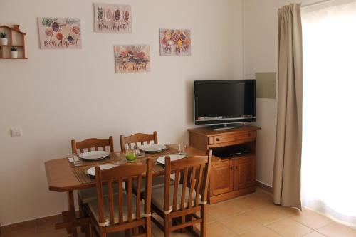 a dining room with a table and a television at Casinha dos Avós in Lagos