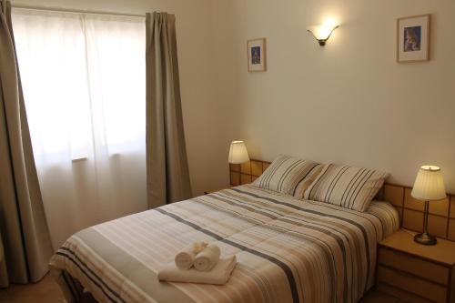 een slaapkamer met een bed met twee handdoeken erop bij Casinha dos Avós in Lagos