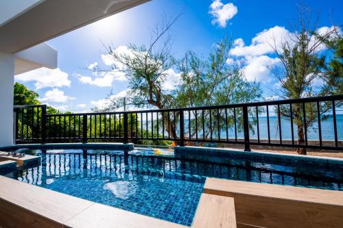a swimming pool with a view of the ocean at The Peridot Smart Hotel Tancha Ward in Onna