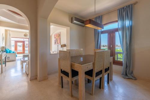 una sala da pranzo con tavolo e sedie in legno di Scenic Views 3 bedroom Villa with private jacuzzi in Sabina a Hurghada