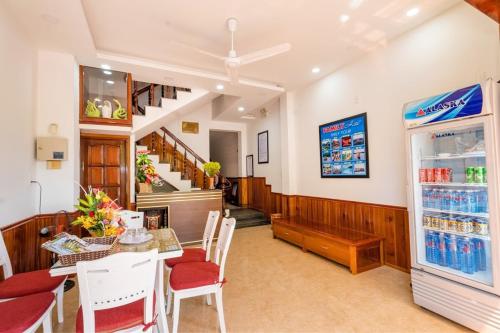uma sala de jantar com uma mesa e um frigorífico em Family Hotel em Hoi An