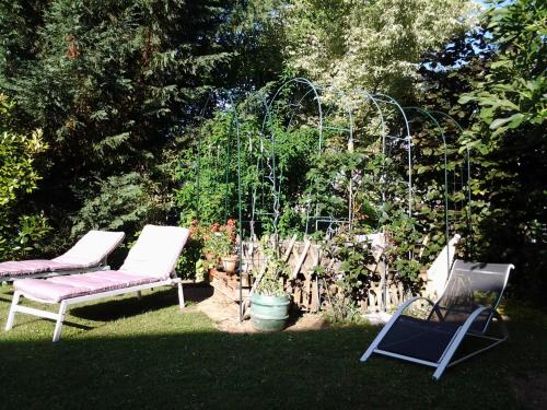 two chairs and a swing in a yard at Les 3 Clés in Dossenheim-Kochersberg