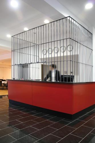 a large cage with a man in an office at ALCATRAZ Hotel am Japanischen Garten in Kaiserslautern