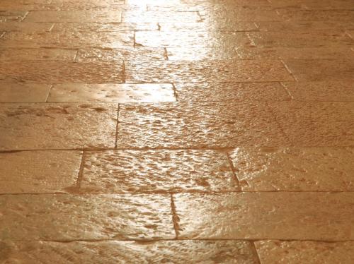 a brick sidewalk with the sun shining on it at Pietraluce in Alberobello
