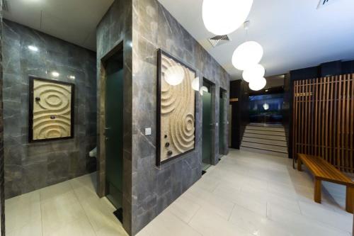 a hallway of a building with a bench and paintings at Zen Next Khao Yai By ZV in Pak Chong