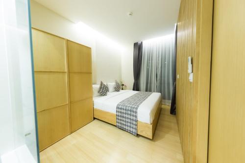 a small bedroom with a bed and a closet at Zen Next Khao Yai By ZV in Pak Chong