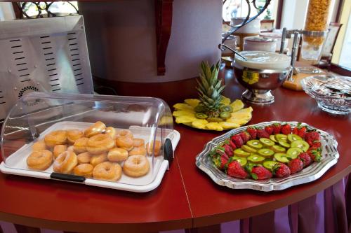 a table with two trays of donuts and fruit at Hotel Vittorio in Desenzano del Garda