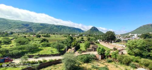 a town in a valley with mountains in the background at Radhika Palace Hotel in Pushkar