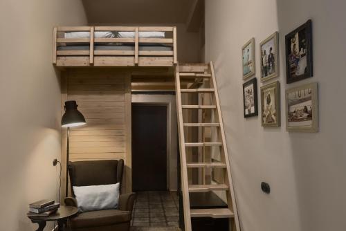 a room with a loft bed and a chair at Brick Walls Hotel in Omsk