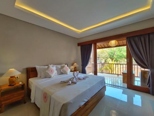 ein Schlafzimmer mit einem großen Bett und einem Balkon in der Unterkunft Surawan Bisma Ubud in Ubud
