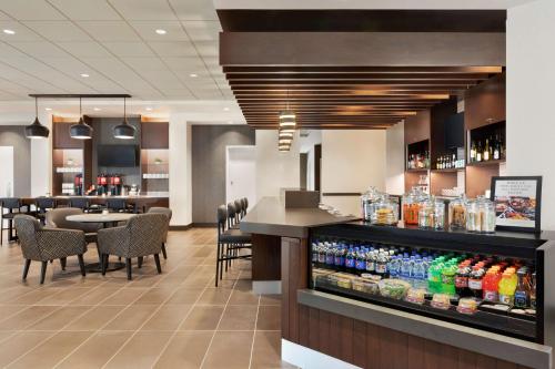 a restaurant with a bar with bottles of soda at Hyatt Place Virginia Beach Town Center in Virginia Beach