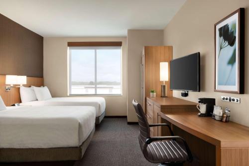 a hotel room with two beds and a desk and a tv at Hyatt Place Virginia Beach Town Center in Virginia Beach