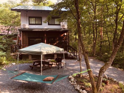 a house with a tent in front of it at Ryder's House with Free use of 4W car in Hakuba
