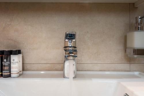 a faucet on a sink in a bathroom at White Rock Milos Suites in Adamas
