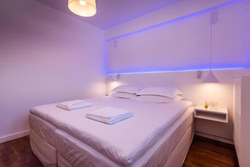a bedroom with a white bed with two towels on it at White Rock Milos Suites in Adamas