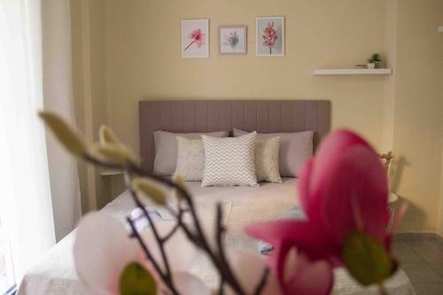 a bedroom with a bed with a pink flower in the foreground at Nikoletta's Studio in Komotini