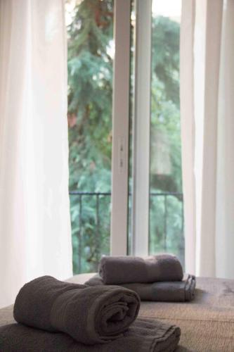 two towels on a bed in front of a window at Nikoletta's Studio in Komotini