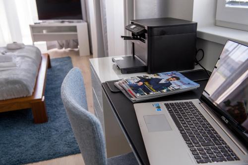 a desk with a laptop computer and a printer at More Than Accommodation in Bratislava