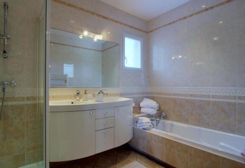 La salle de bains est pourvue d'un lavabo, d'une baignoire et d'un miroir. dans l'établissement LE CLOS D'IGNAC, à Lège-Cap-Ferret