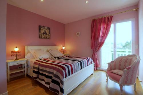 a bedroom with a bed and a chair and a window at LE CLOS D'IGNAC in Lège-Cap-Ferret