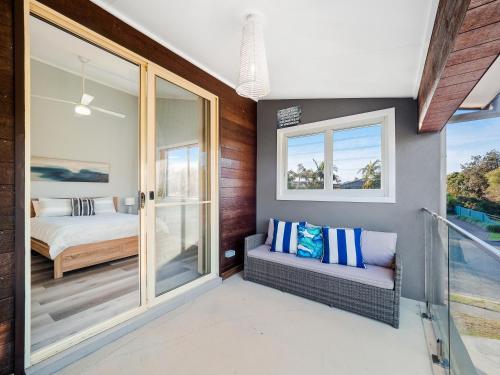 a bedroom with a bed and a balcony at Myley's Flat in Forster