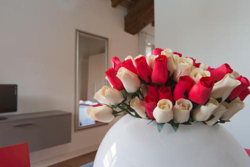 a bouquet of red and white roses in a vase at L'Altana City House in Brescia