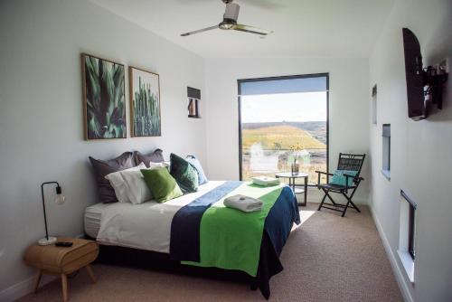 a bedroom with a bed and a large window at Dragonfly Cottages in Orange