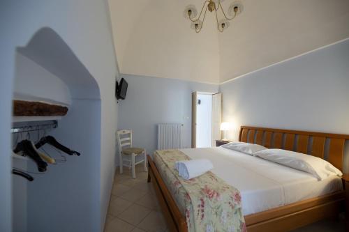 een slaapkamer met een bed en een stoel in een kamer bij Dimora del Murattiano in Monopoli