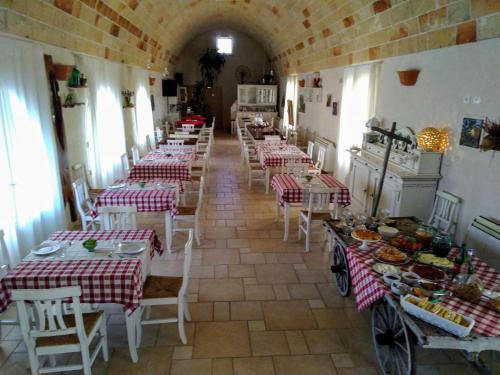 a restaurant with red and white tables and chairs at Masseria Stellato in Nardò