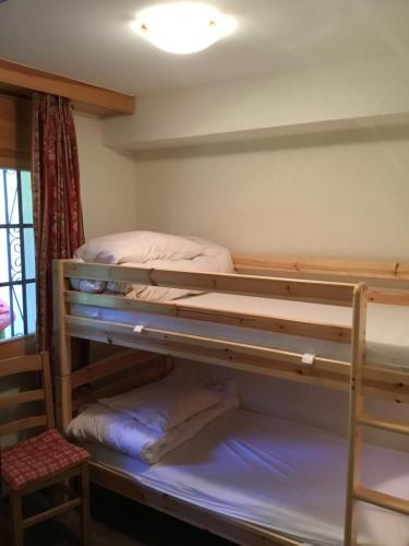two bunk beds in a room with a window at Rue de Bel-Aube Chalet Joli 10 in Crans-Montana