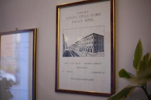 a framed picture of a building on a wall at Hotel Europa in Ferrara
