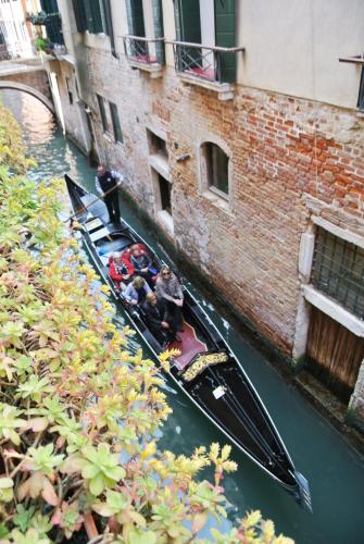 a group of people riding in a gondola down a canal at Uma Apartments in Venice