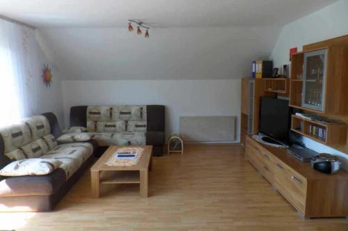 a living room with a couch and a tv at Ferienwohnung Landsbergblick in Walldorf