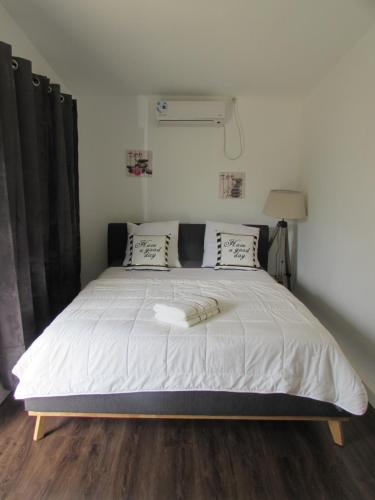 1 dormitorio con 1 cama grande con sábanas blancas en "Tom" Chez Tom et Dilou, en Kumak