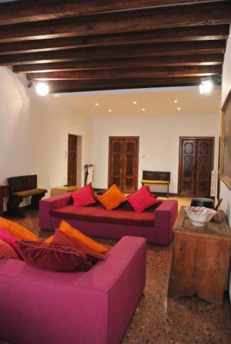 a living room with two purple couches and a table at Uma Apartments in Venice