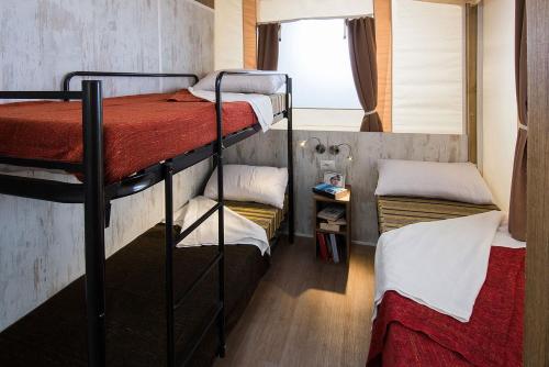 a small room with two bunk beds in it at Camping Village Mar y Sierra in San Costanzo