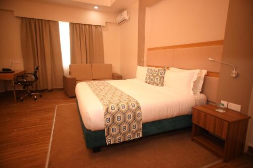 a hotel room with a bed and a chair at PrideInn Plaza Nairobi Airport in Nairobi