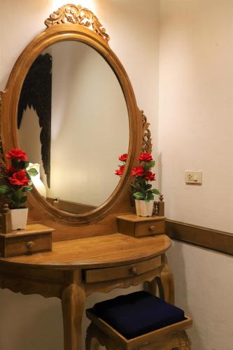 a mirror on top of a wooden table with flowers at Right Spot in Pattaya South