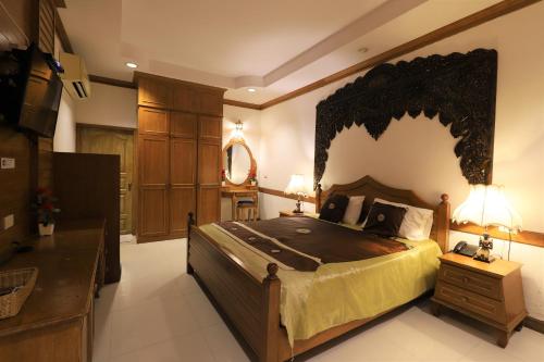 a bedroom with a large bed with a large headboard at Right Spot in Pattaya South