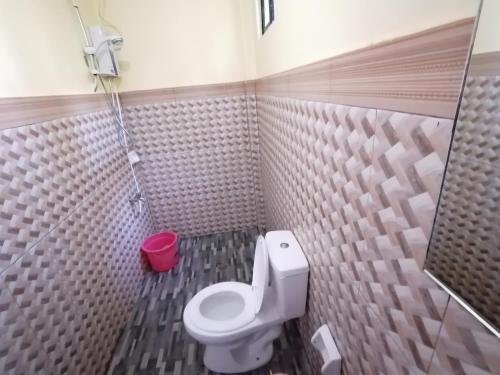 La salle de bains est pourvue de toilettes et d'un seau rouge. dans l'établissement Mariner's Pension House, à Puerto Princesa