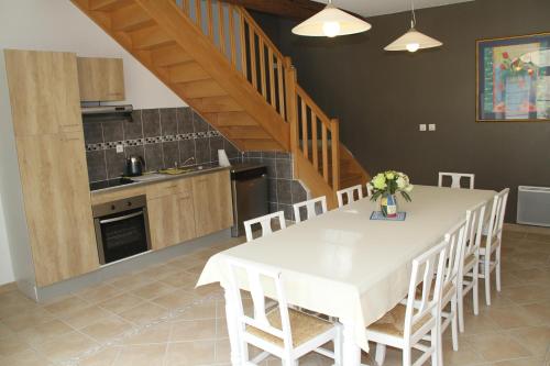 a kitchen and dining room with a white table and chairs at Alba Cottage in Bitry