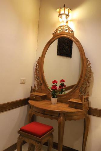 a wooden dressing table with a mirror and a stool at Right Spot in Pattaya South
