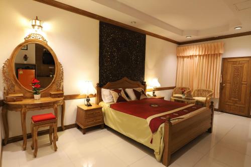 a bedroom with a bed and a mirror and a table at Right Spot in Pattaya South