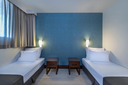 two beds in a room with two lamps on them at King Solomon by Isrotel Collection in Eilat