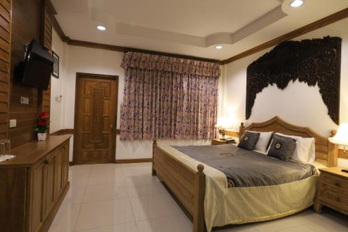 a bedroom with a large bed and a television at Right Spot in Pattaya South