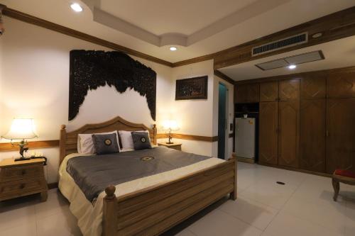 a bedroom with a large bed with two lamps and a refrigerator at Right Spot in Pattaya South