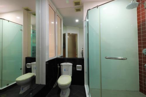 a bathroom with two toilets and a glass shower at Right Spot in Pattaya South