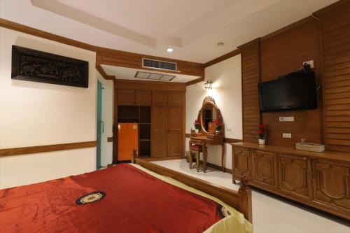 a bedroom with a bed and a flat screen tv at Right Spot in Pattaya South