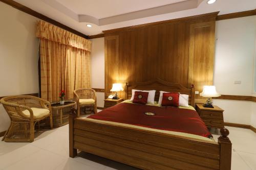 a bedroom with a large bed and two chairs at Right Spot in Pattaya South