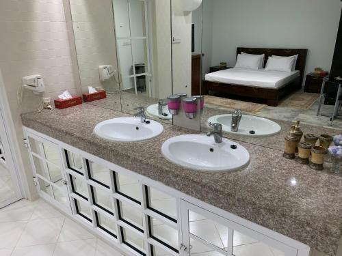 a bathroom with two sinks and a large mirror at Oriental Nights Rest House in Al Wāşil